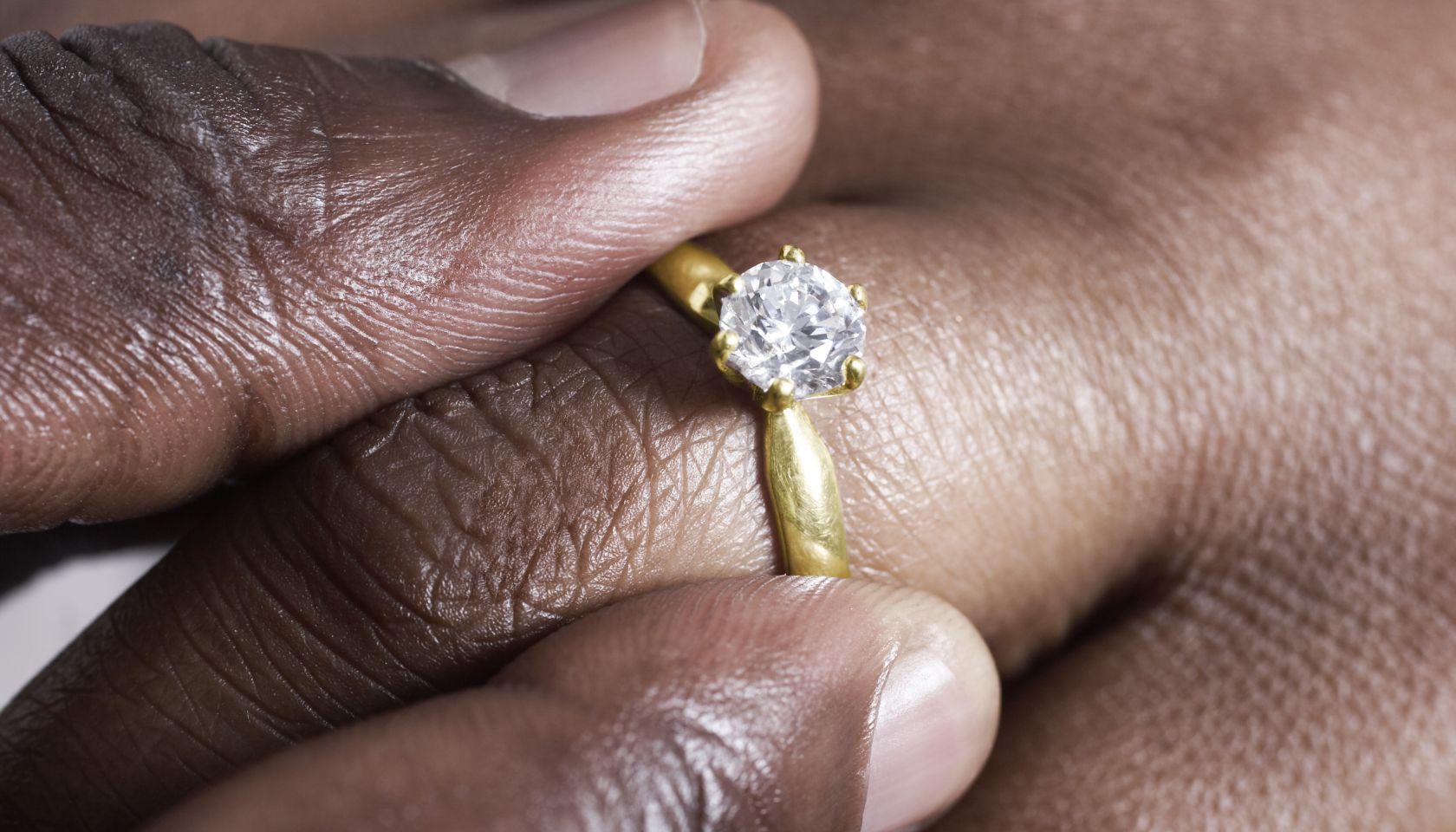 Man putting wedding ring on woman.