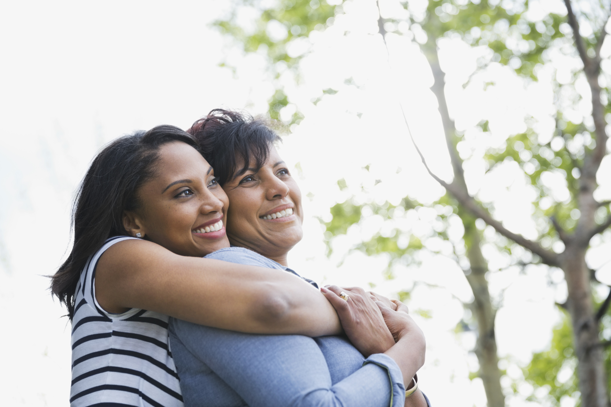 Adult woman embracing mother from behind
