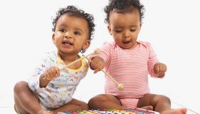 Twin girl and boy playing with xylophone, 18 months