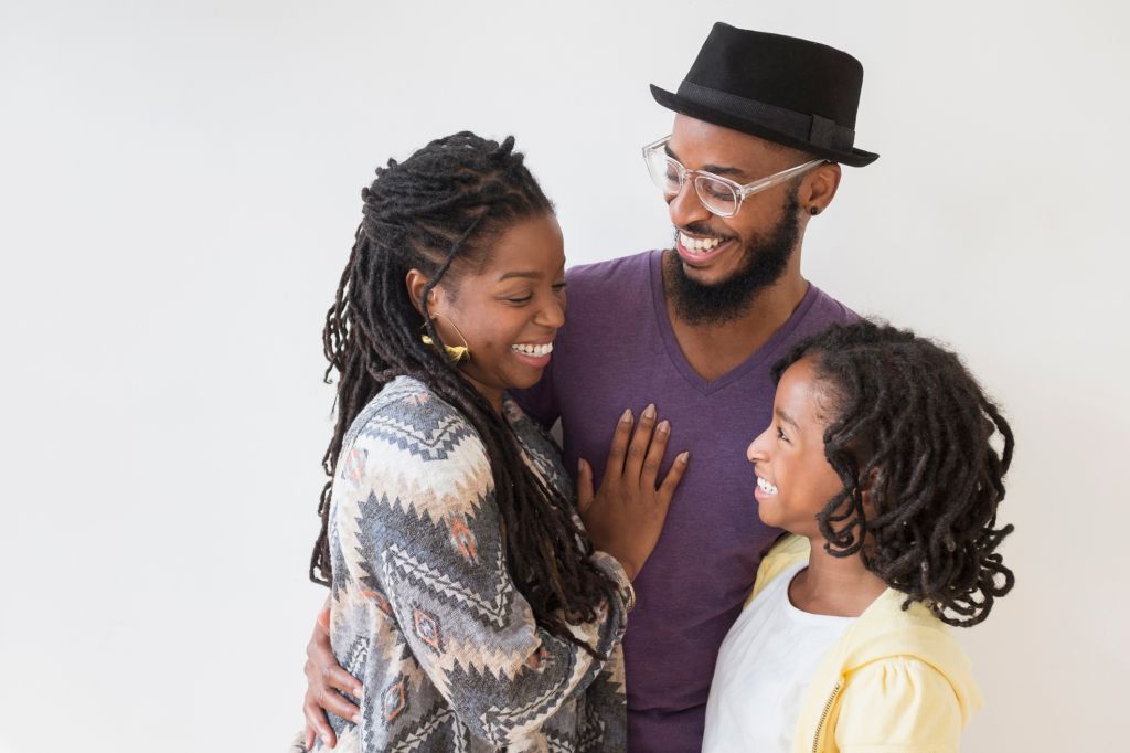 Smiling Black family hugging