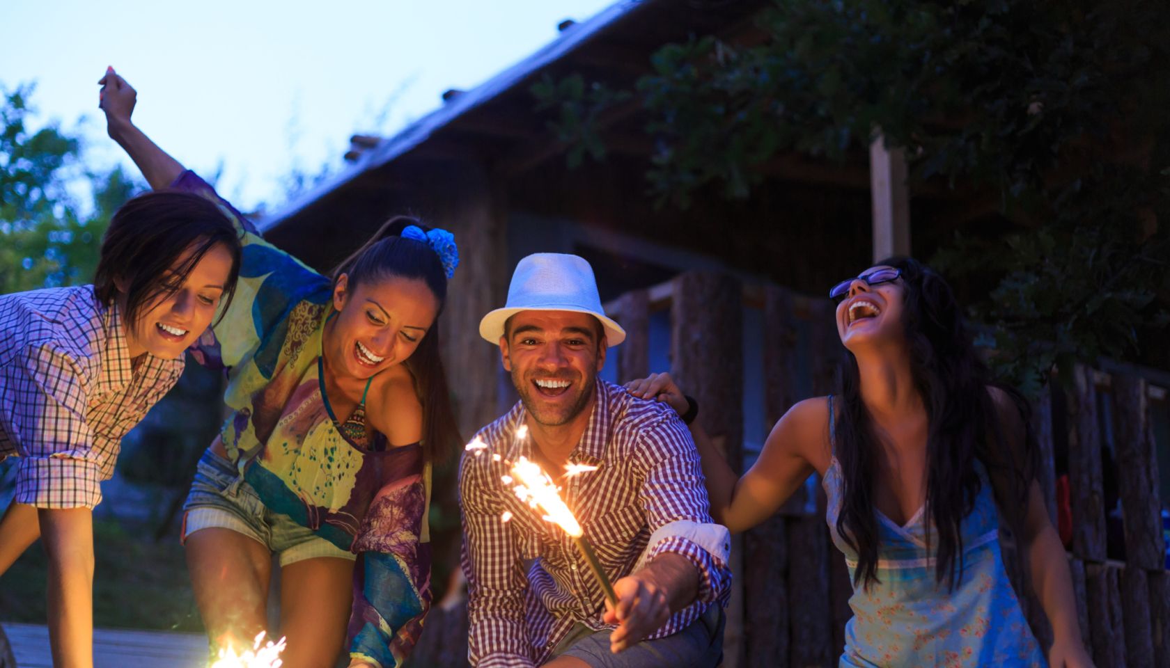 Young people celebrating with fireworks at night