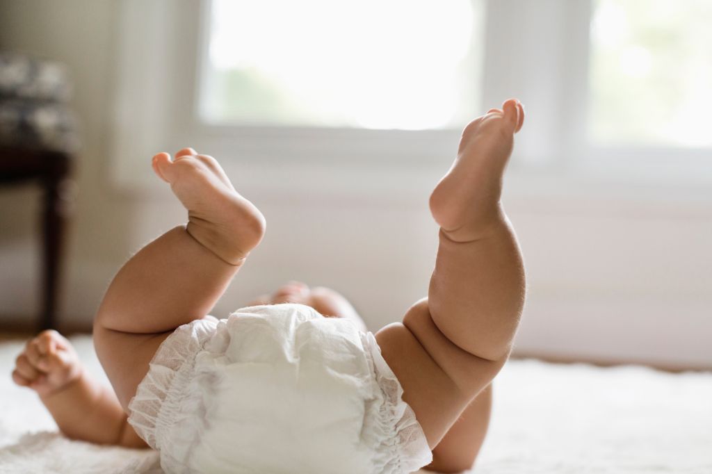 Mixed race baby girl laying on floor