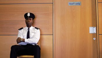 Security guard sitting by office door