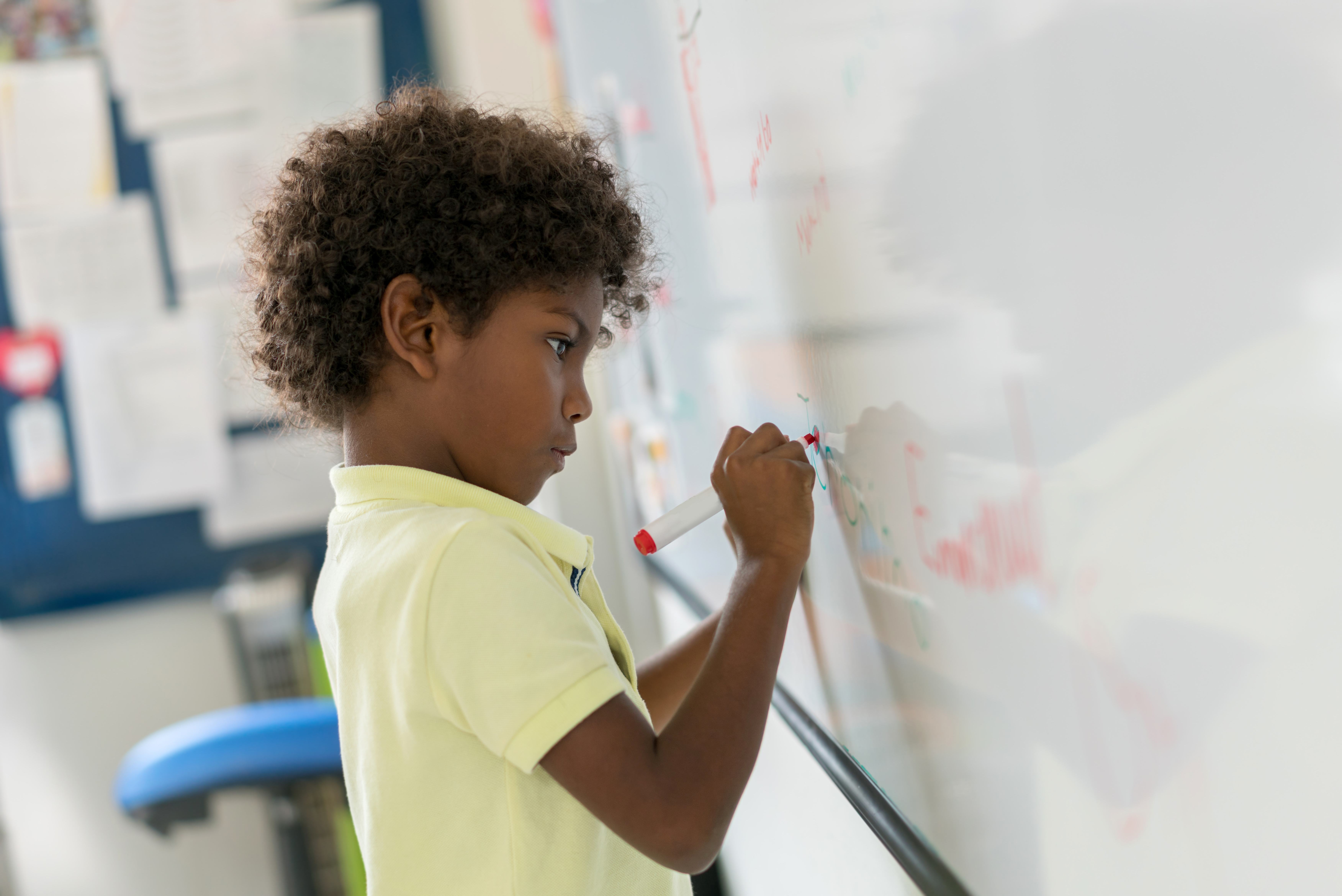 African American boy at the school writing on the board