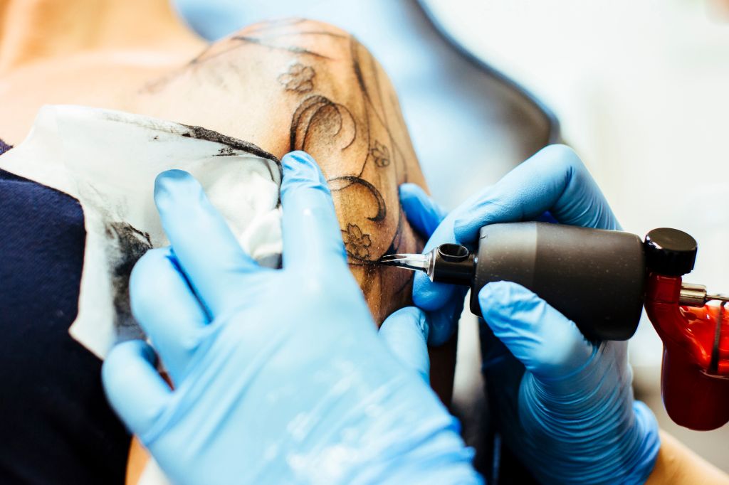 Tattooer in his workshop making a tattoo.