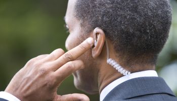 Man with finger on earpiece, rear view