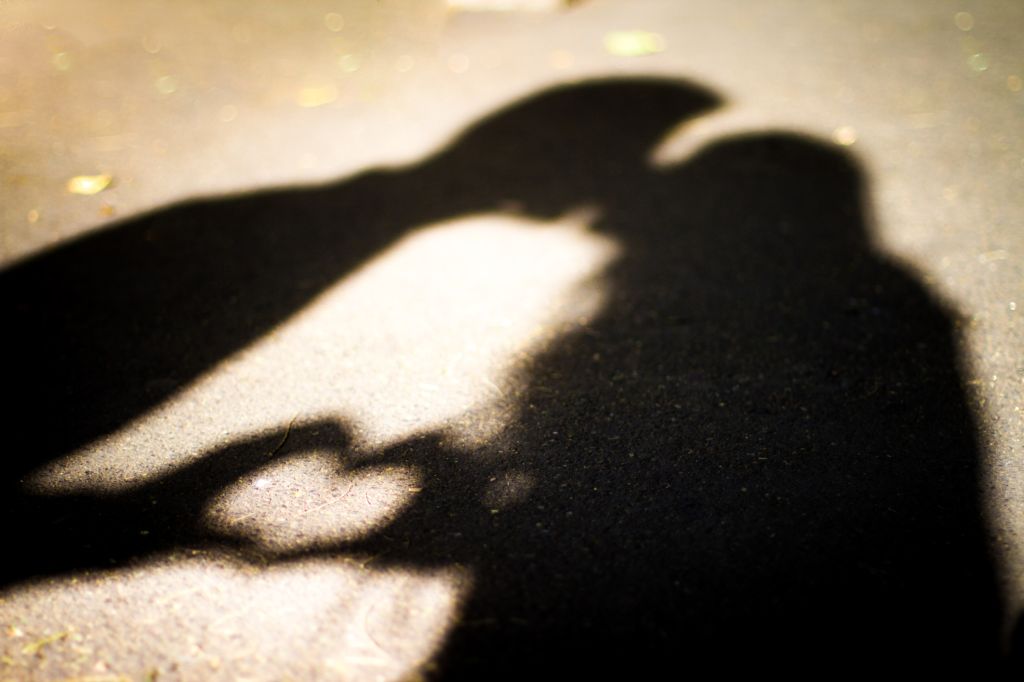 Silhouette of two lovers. Kissing and forming a heart shape.