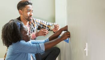 Multi-ethnic couple preparing to paint home