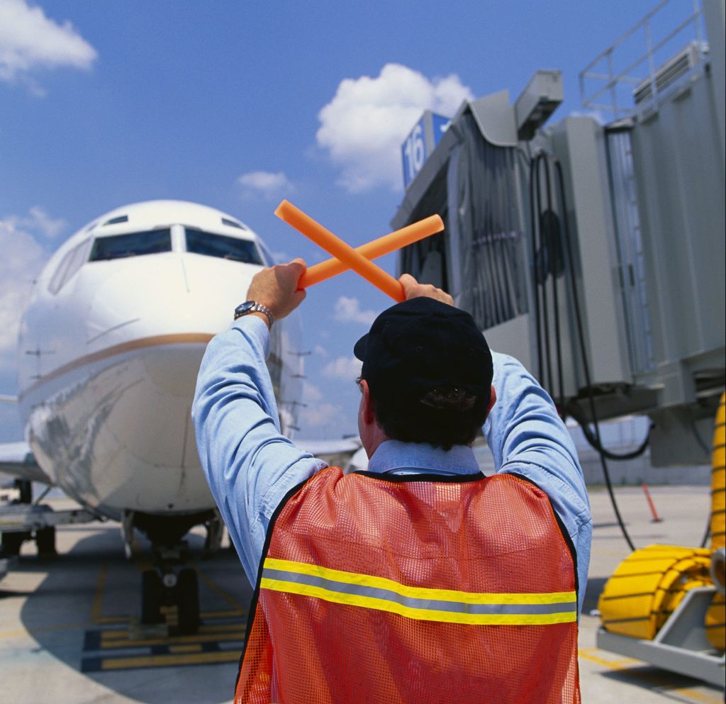 Ground crew directing plane to the gate jetway