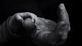 Cropped Hands Of Father And Baby Against Black Background