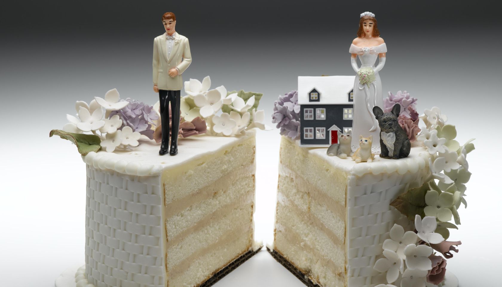 Bride and groom figurines standing on two separated slices of wedding cake