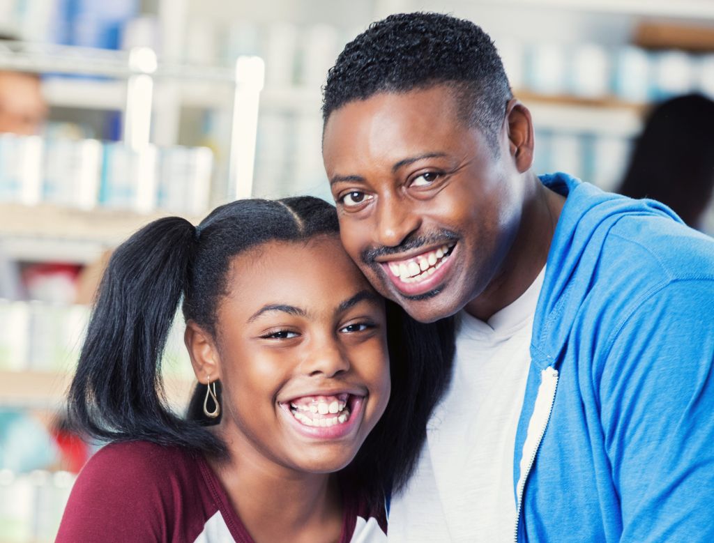 Man volunteers in food bank with his daughter