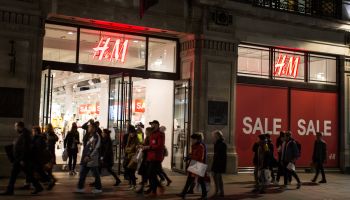 People walk past a 'sale' advertisement from an H&M store on...