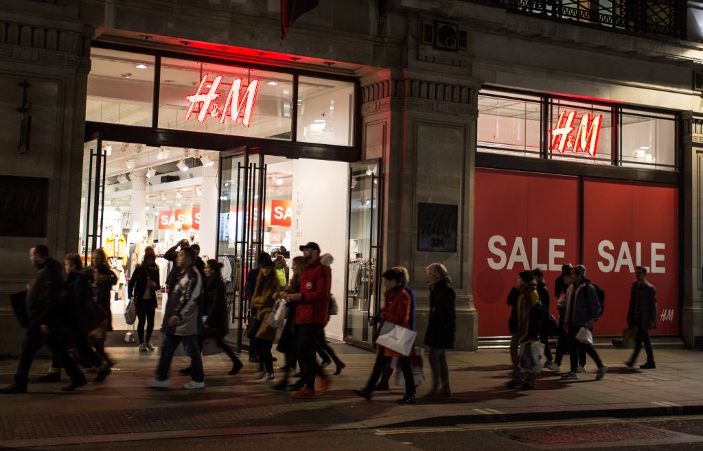 People walk past a 'sale' advertisement from an H&M store on...