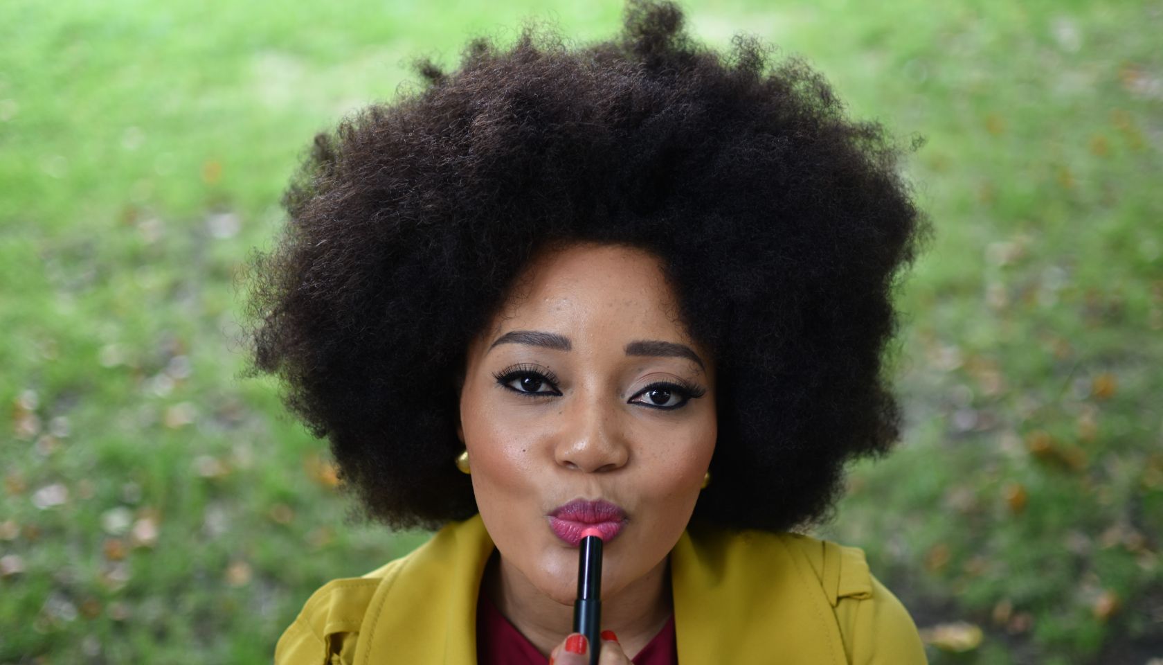 High Angle Portrait Of Woman Applying Lipstick At Field