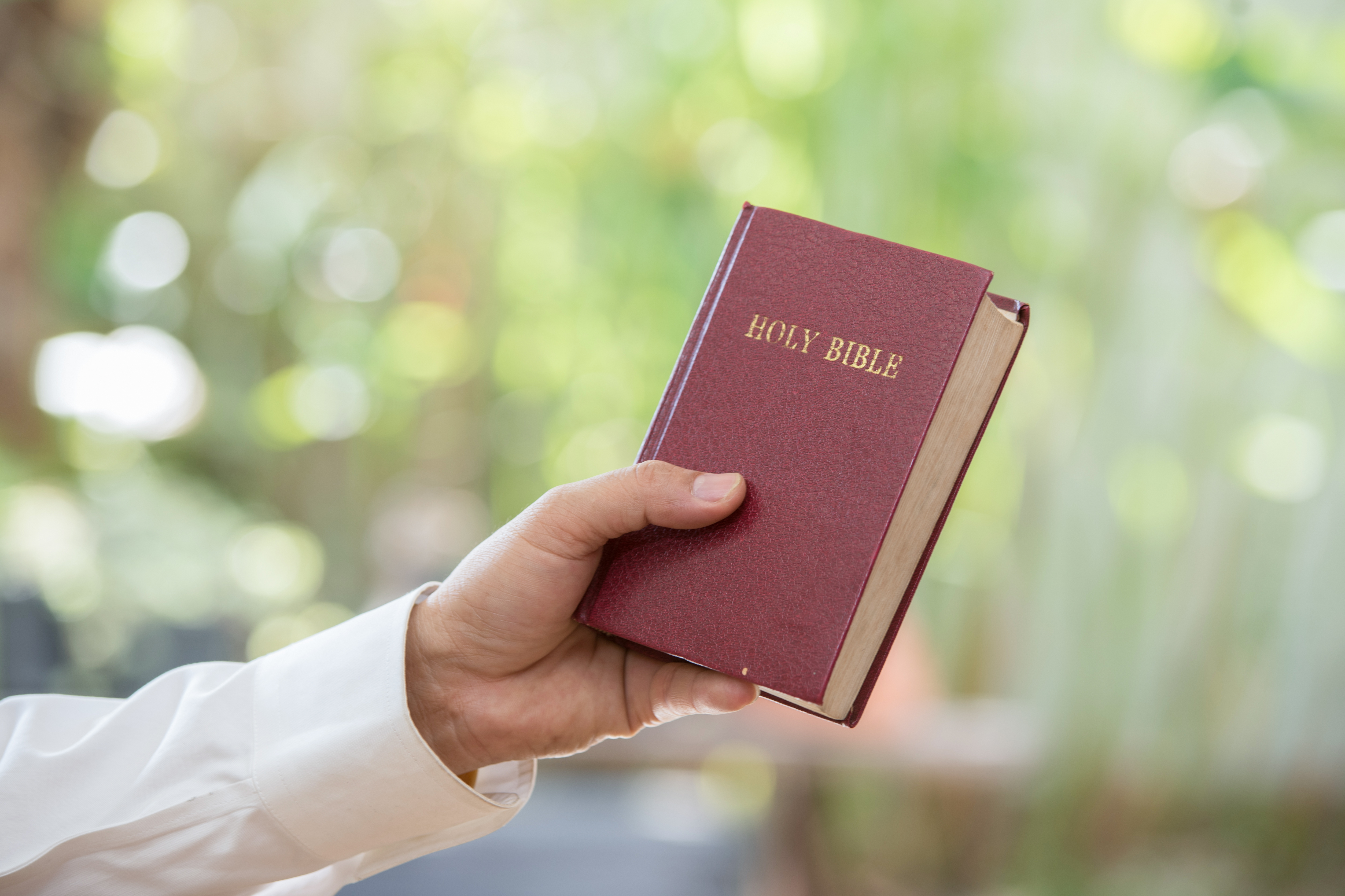 Human hand placed on the Bible, pray to God.