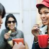 Happy multiracial group of female friends enjoying coffee with snacks.