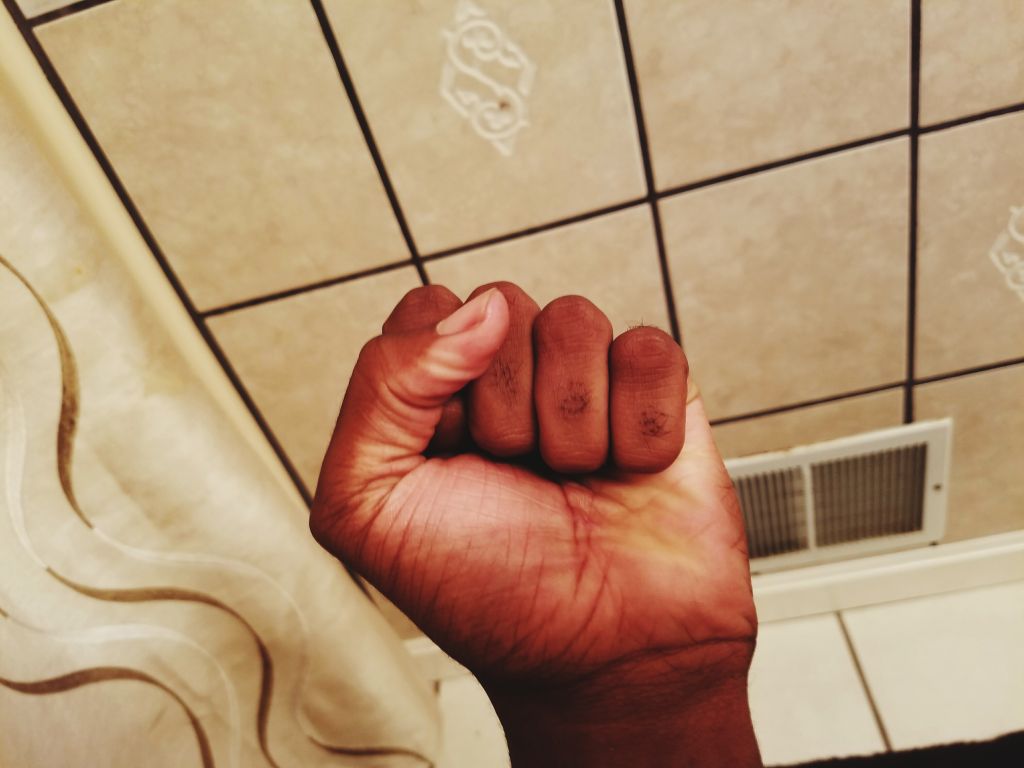 Cropped Hand Clenching Fist Against Ceiling