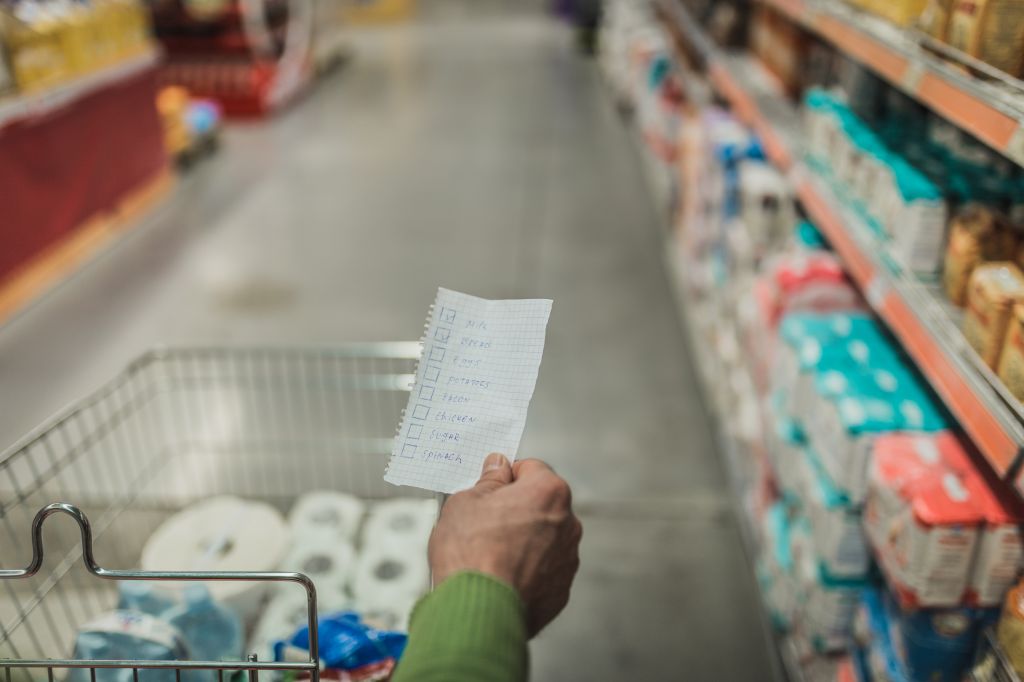 Close-up of a man holding shopping list in the supermarket