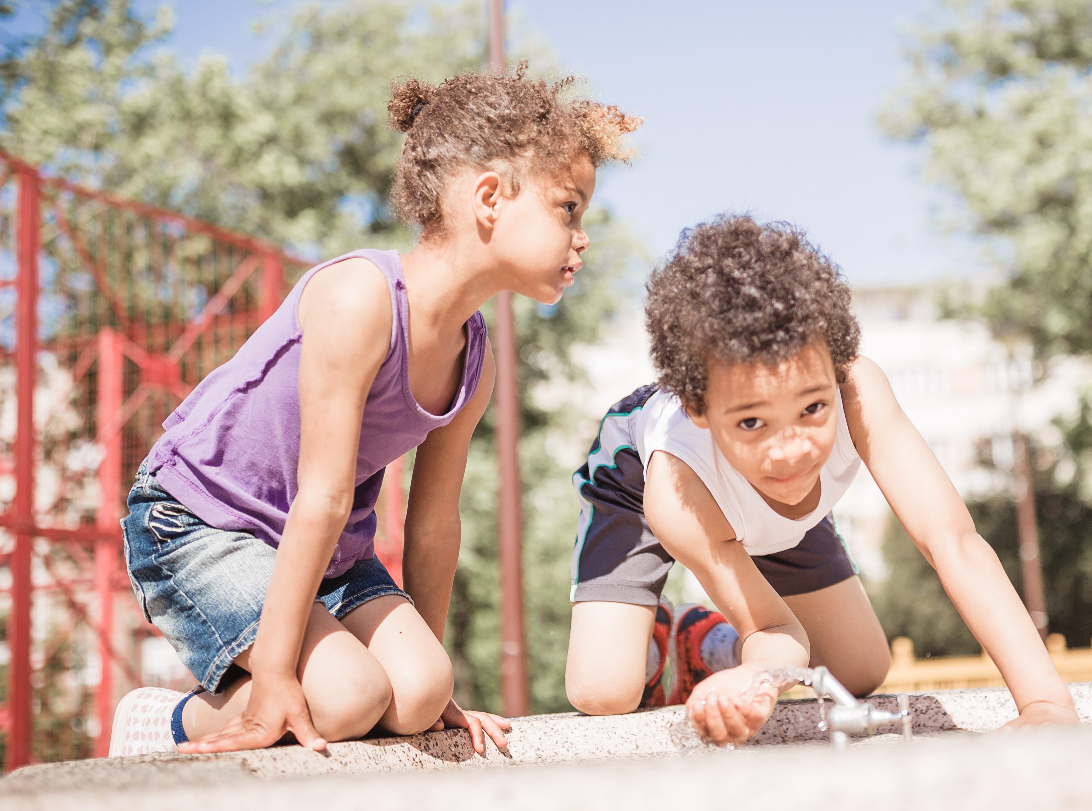 Cute mixed race children playing outdoors in public park