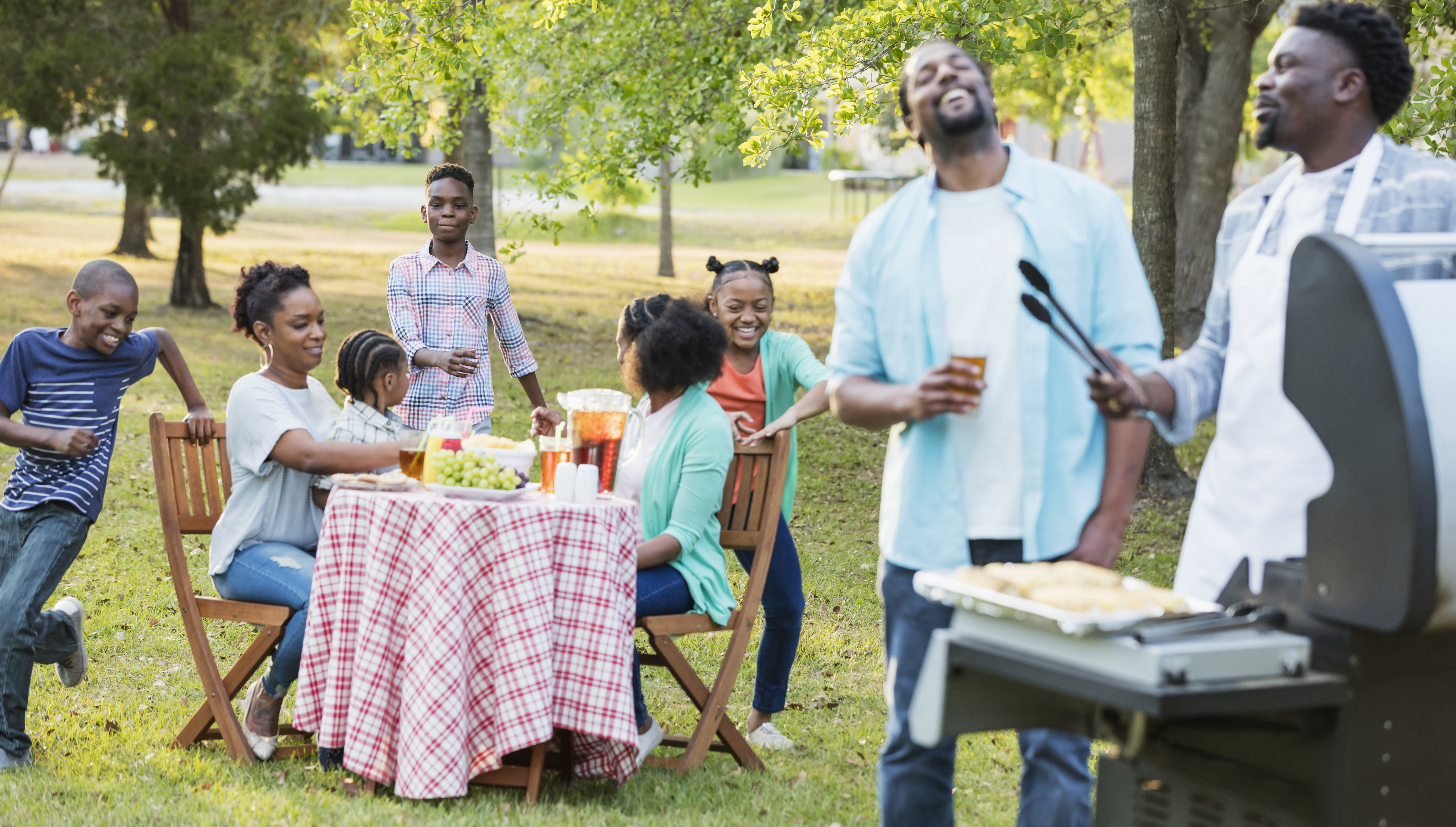 Large African-American family having backyard cookout