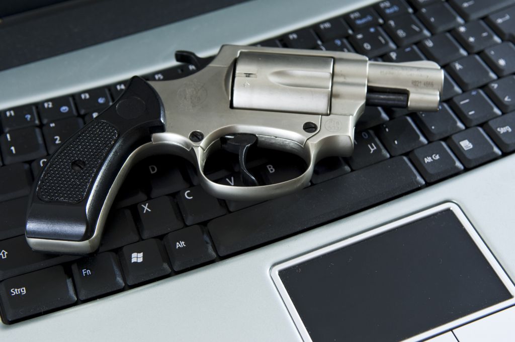 Pistole auf dem Laptop, Computerkriminalität