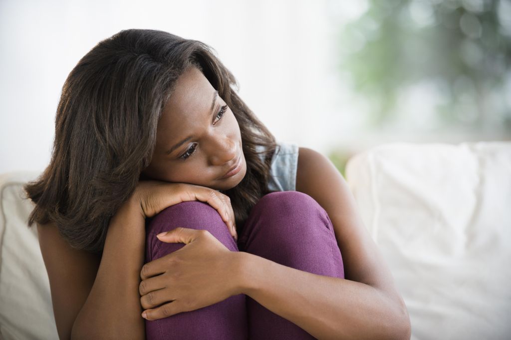 Black woman hugging her knees