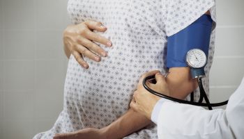 Doctor taking blood pressure from pregnant woman