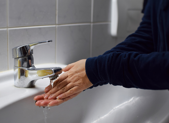 Midsection Of Man Washing Hands At Sink