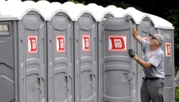 Tony Paine cleans one of 44 porta potty's that he and his crew are installing around Yarmouth today