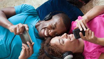 Man and woman playing on handheld device and smartphone