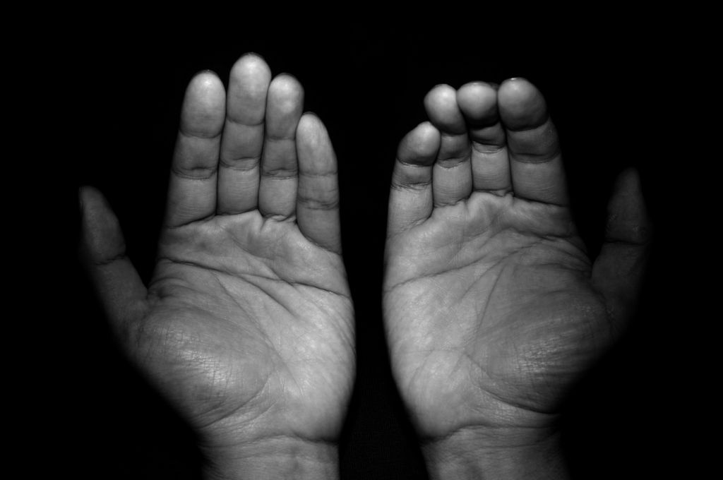 Close-Up Of Hands Against Black Background