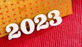 Happy new year 2023 - White wooden letters on red background