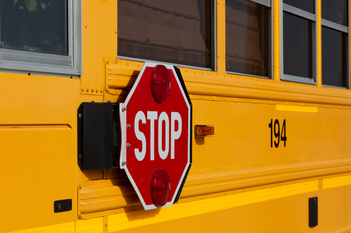 Stop road sign at the school bus