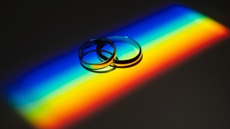 Rainbow beam on wedding rings. lgbt flag.