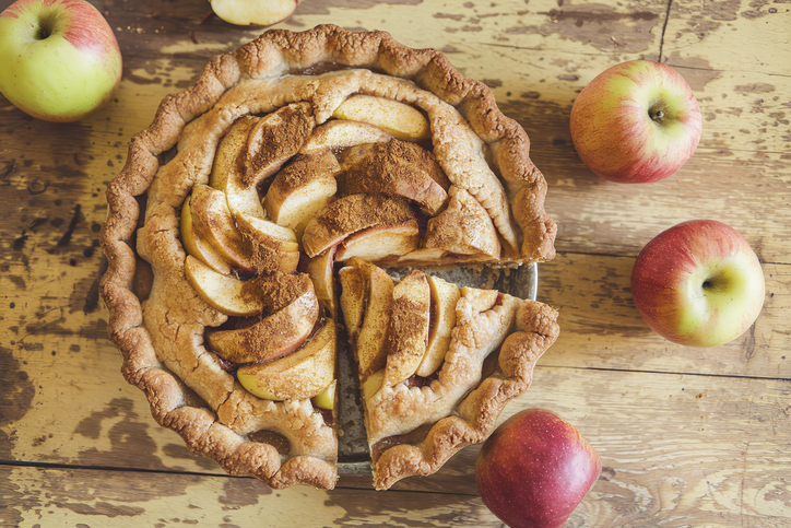 Homemade apple pie and cinnamon on vintage wooden background texture Top view
