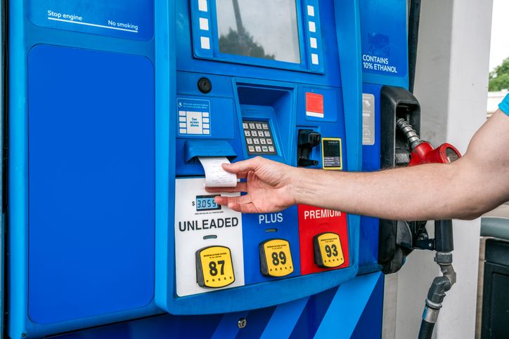 Man Waits for Credit Card Receipt at Gas Station